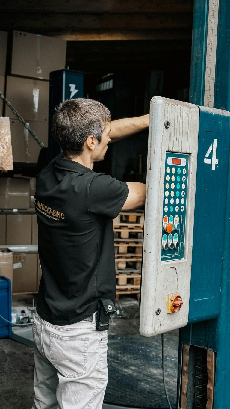 Man operating a loading dock panel, managing warehouse logistics for efficient operations.